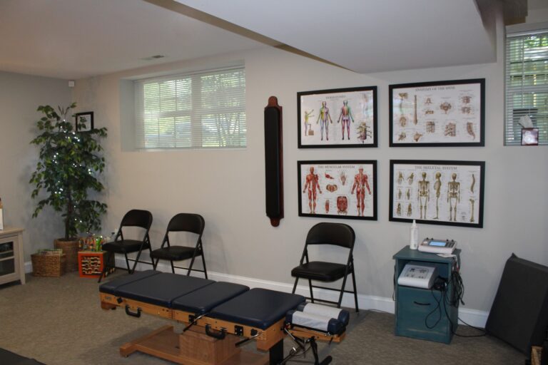 Chiropractor office with charts and adjustment table.