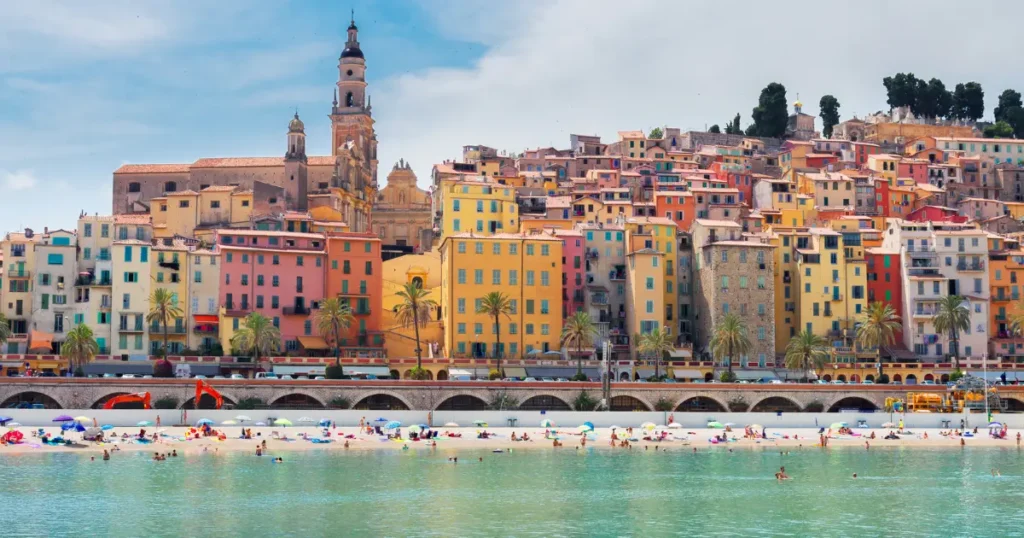 Colorful coastal town with busy beach scene.